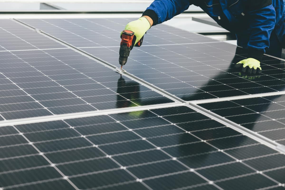 Worker installing solar panels on a rooftop