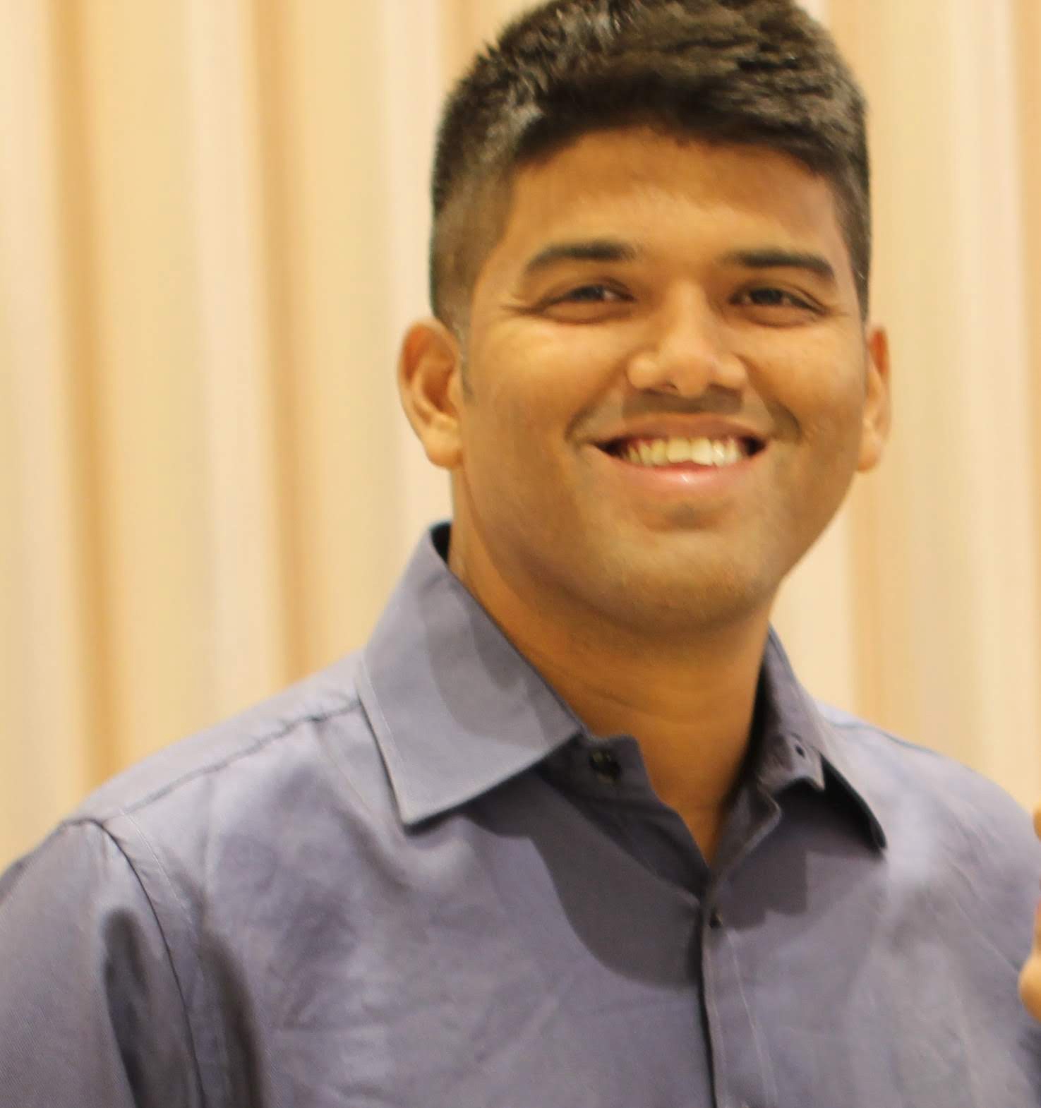 Rohan R. Kotwalkar standing on a beach with the ocean in the background
